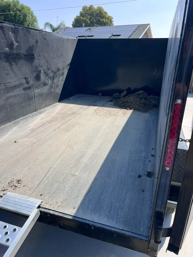 Empty dump trailer bed with the loading ramp down