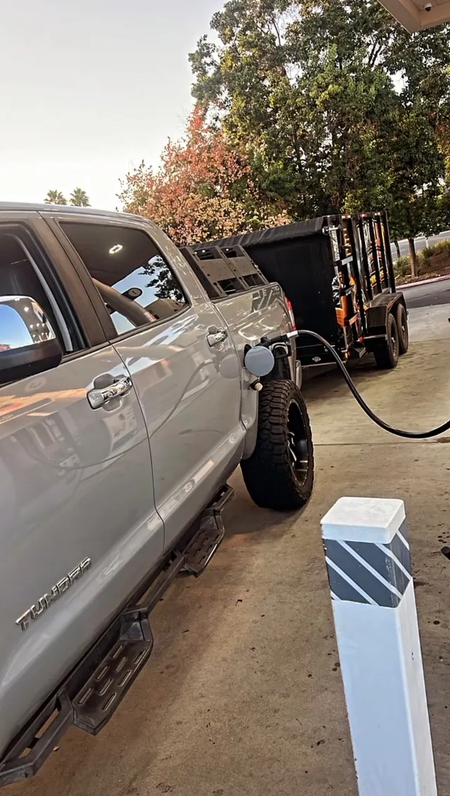 Pro Lift pickup and trailer at a gas station pump