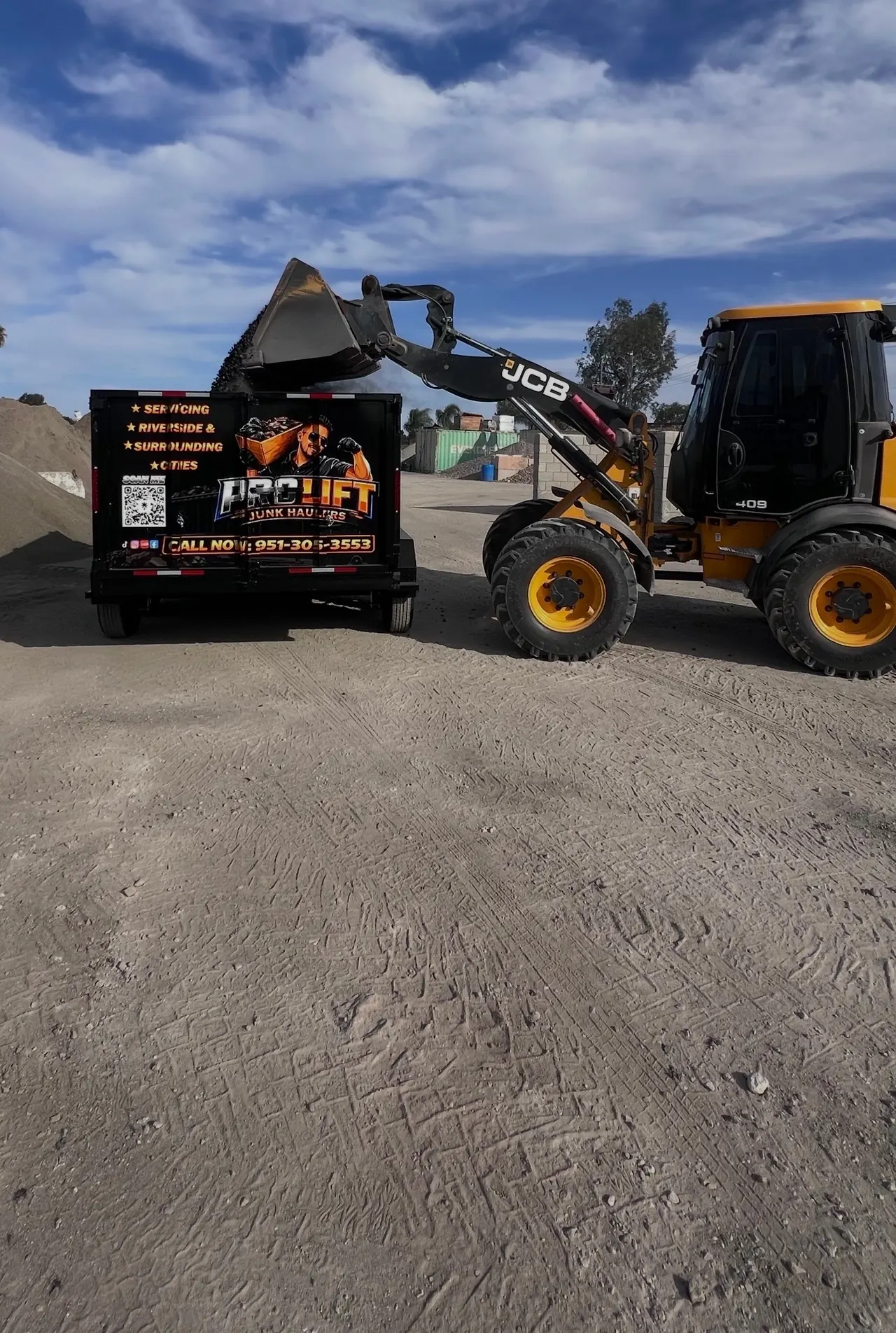 Front loader dumping dirt into the Pro Lift trailer